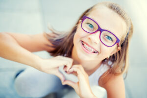 smiling girl with glasses and braces